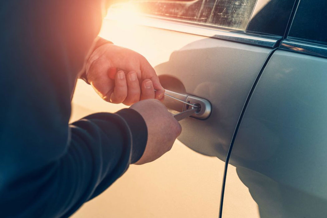 Hands working a car door lock at sunset